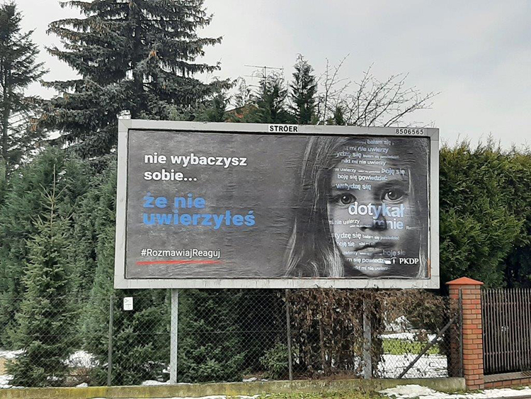 Billboard na tle drzew. Na billboardzie zdjęcie dziewczynki i napis: nie wybaczysz sobie... że nie uwierzyłeś