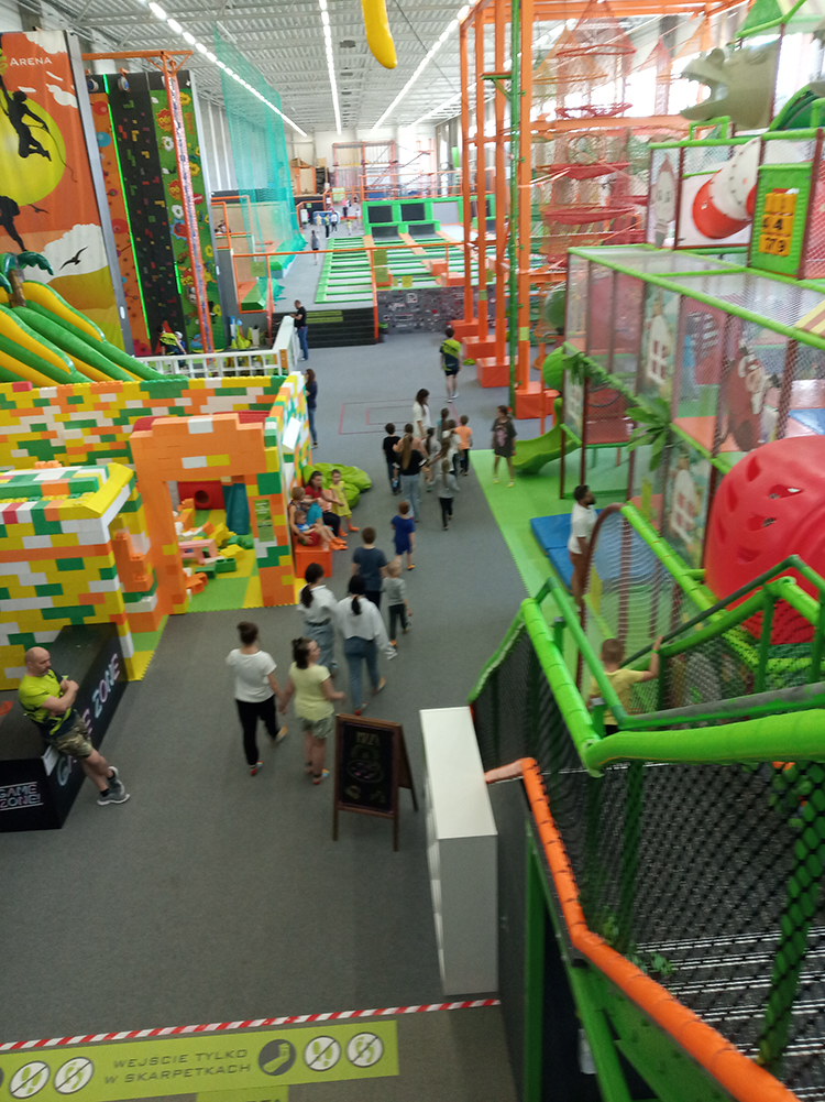 Ludzie idą korytarzem w parku trampolin