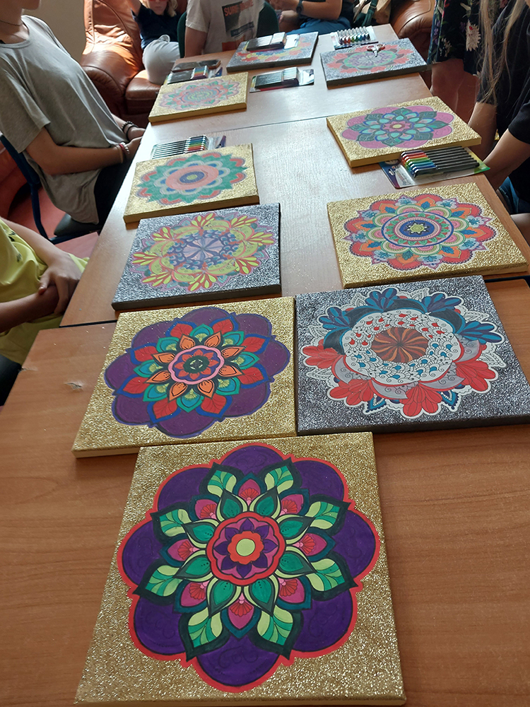 Na stole leżą namalowane na płótnie mozaiki