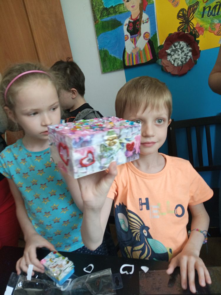2 dzieci, jedno pokazują ozdobioną szkatułkę