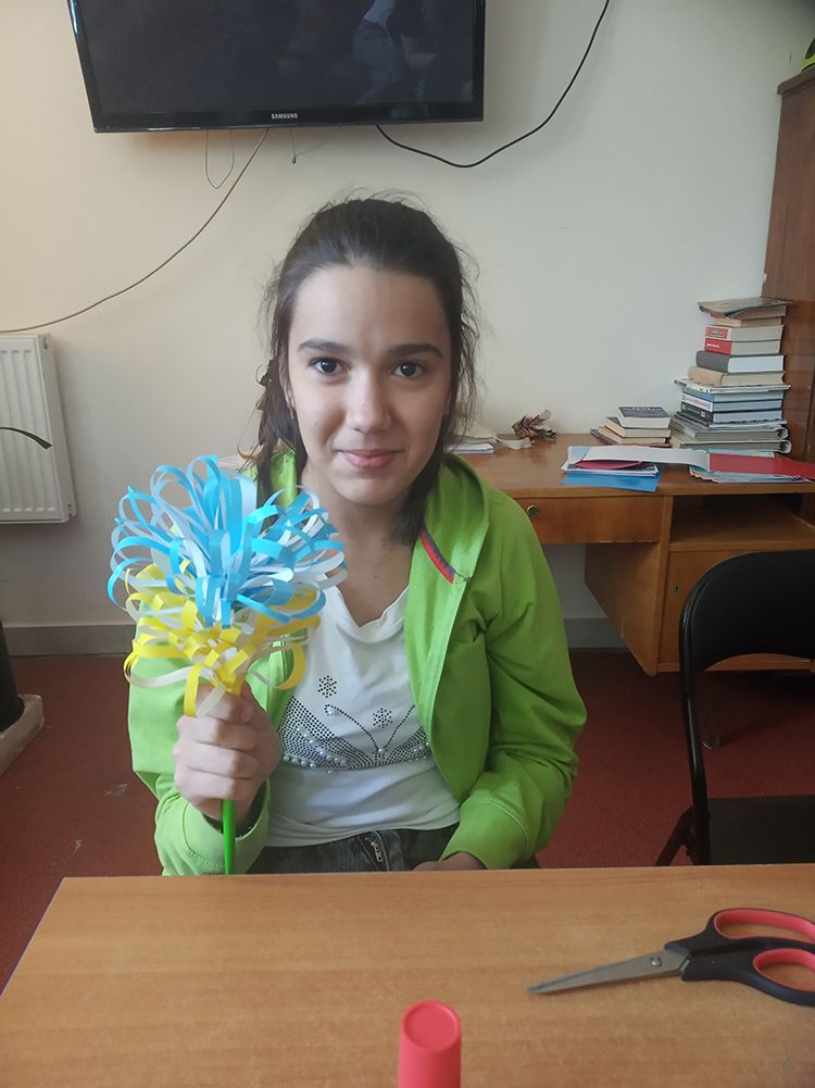 Dziewczynka trzyma papierowy kwiat
