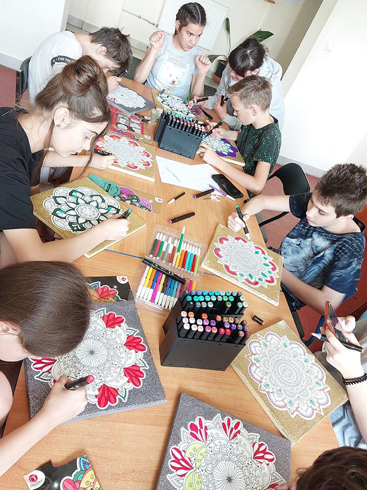 Dzieci przy stole kolorują mozaiki